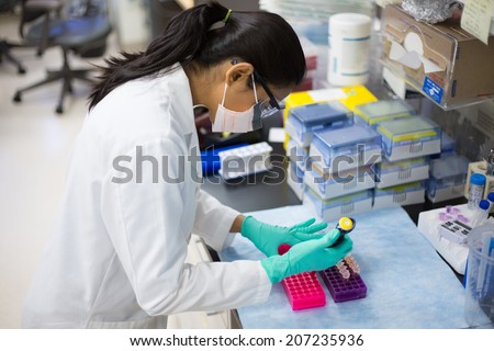 Closeup portrait, young scientist in labcoat doing experiments in lab, academic sector. Royalty-Free Stock Photo #207235936