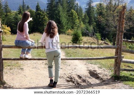 Women enjoying mountain landscape on sunny day, back view. Space for text