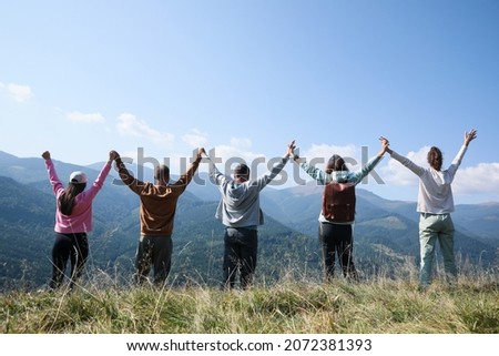 Group of people spending time together in mountains, back view Royalty-Free Stock Photo #2072381393