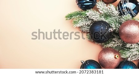 Merry Christmas and Happy New Year pastel background with blue and pink Christmas balls with golden greeting text, banner top view