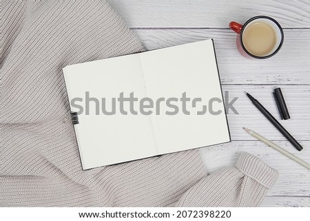 Notepad, book, planner, journal, diary mockup for text or design, open blank notebook top view, flat lay with cozy sweater and coffee cup.