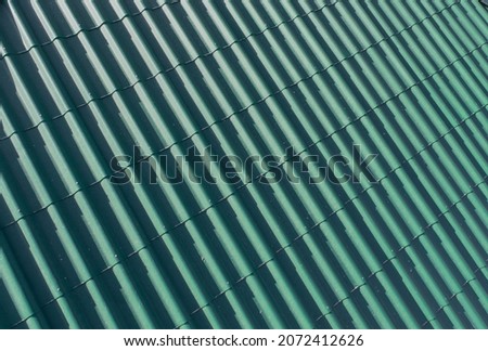 Modern roof. Roof covering. Roman profile. The roof of the house is covered with green undulating tiles. Royalty-Free Stock Photo #2072412626
