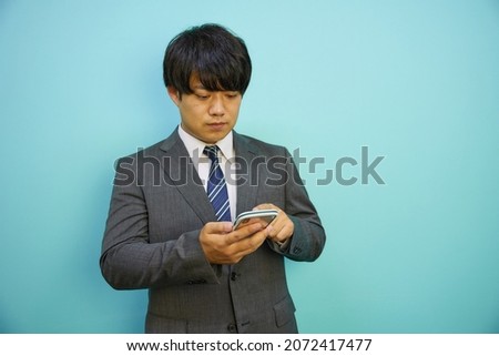 Asian man operating a mobile phone