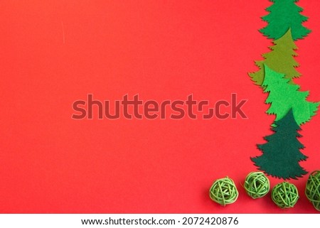 New Year's layout on a red background, mittens, sled, wooden New Year's train, with wooden Christmas trees. 2022