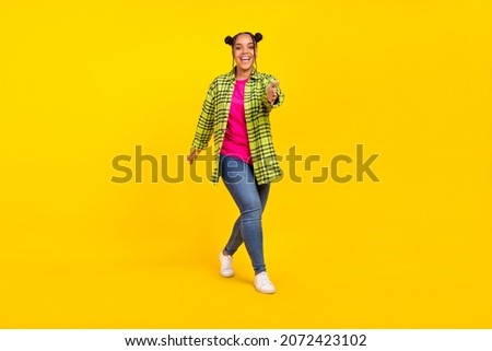 Full body photo of happy positive young woman give handshake you smile walk isolated on yellow color background