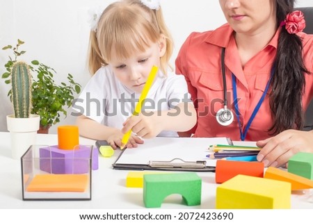 A 3-4-year-old girl draws with pencils at a psychologist's appointment, the development of a child's psyche