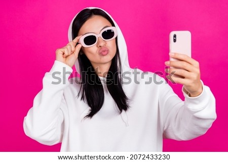 Photo of young millennial girl eyeglasses pouted lips record videp cellphone isolated over magenta color background