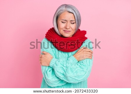 Photo of ill grey hairdo aged lady hug herself wear scarf teal sweater isolated on pink color background