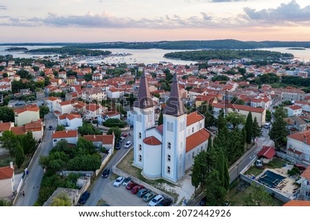 An aerial shot of Medulin at dusk, in the foreground church of Sv. Agnes with two bell towers, Istria, Croatia