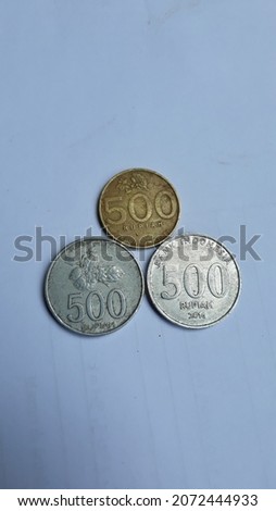 old coins and Indonesian banknotes as a medium of exchange in economic activities with a white background