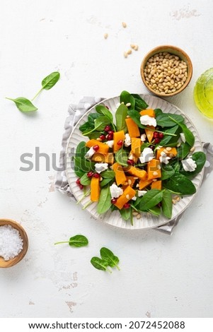 Roasted pumpkin and feta salad top view winter food on light surface