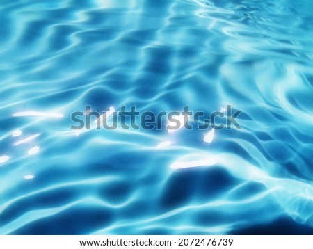 Blur​ abstract​ of​ surface​ blue​ water. Abstract​ of​ surface​ blue​ water​ reflected​ with​ sunlight​ for​ background. Blue​ sea. Blue​ water​ splashed​ use​ for​ graphic​ design.