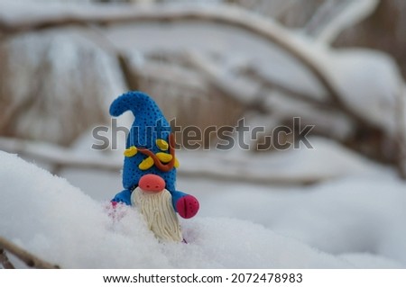 Figure of a dwarf in a snowy forest.