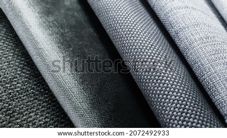 samples of curtain or drapery fabric. production of upholstered for furniture furnishing, details. macro view photo, selective focus at grey fabric texture. grey and white fabric samples swatch. Royalty-Free Stock Photo #2072492933