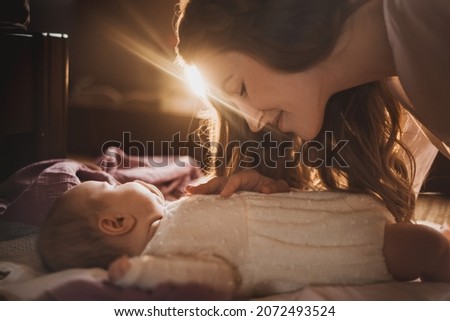 Magic tenderness photo of mother and little baby girl in the bedroom
