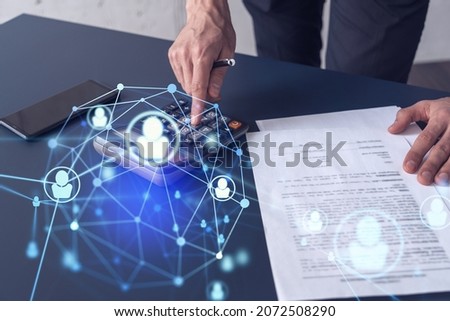 HR specialist researching and analyzing the data of salary on employment market to forecast ongoing expenses of the company using calculator. Hiring new talented officers. Social media hologram icons Royalty-Free Stock Photo #2072508290