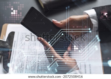 Businesswoman in formal wear checking the phone to sign the contract to create a software to present it at start up conference and gain investments for innovative service. Hologram tech graphs.