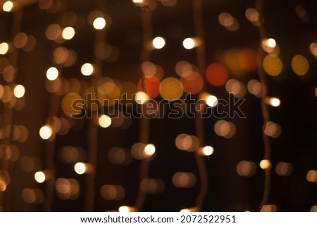 Abstract bokeh lights. Defocused shining yellow light leaks on dark background. New year, christmas garlands flecks