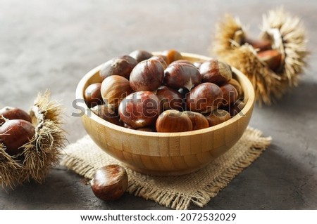 Fresh raw chestnuts on rustic table, Chestnut with thorny branch Royalty-Free Stock Photo #2072532029
