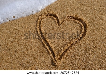 Heart sign written on sand in evening sunlight