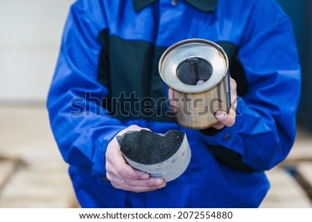 A macro shot of a piece of cut metal catalyst, Man's hands hold cut muffler car with a platinum catalyst. Muffler of the exhaust system of the car  Royalty-Free Stock Photo #2072554880