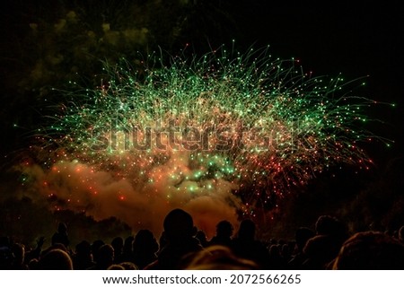 Silhouetted people watching a firework display