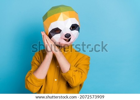 Photo of adorable funny sloth man hands cheeks relax chill free time wear mask yellow shirt isolated blue color background