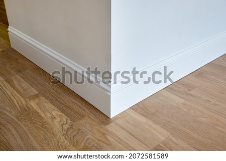 Detail of corner flooring with intricate crown molding and plinth.  Royalty-Free Stock Photo #2072581589