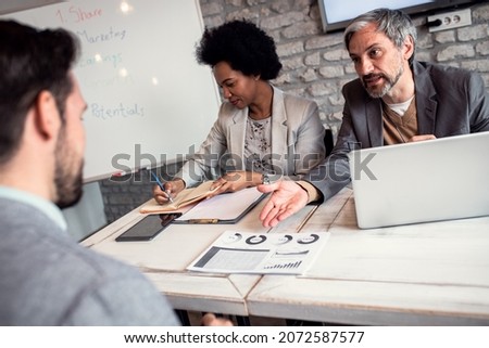 Business recruiters talking with candidate during job interview.