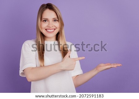 Photo of cheerful lady direct finger blank space hand hold invisible object wear casual t-shirt Royalty-Free Stock Photo #2072591183