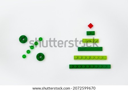 Christmas tree and percent sign made of children's constructor on white background.