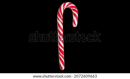 Christmas lollipop isolated on black background. Traditional New Year's sweets. Christmas tree decoration reed