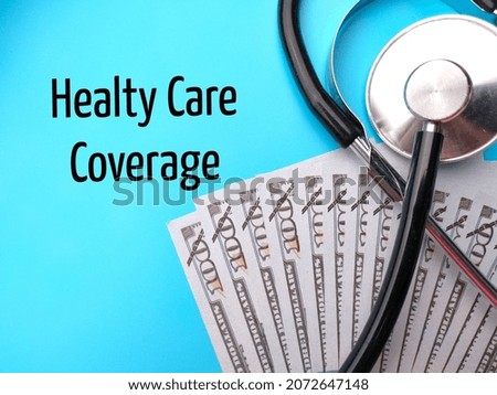 Stethoscope and banknotes with text Healty Care Coverage on blue background.