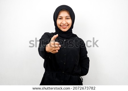 Beautiful young asian muslim woman smiling confidently, with hands shaking the camera, hands sign of cooperation, hand sign of agreement, hand sign of friendship, isolated on white background