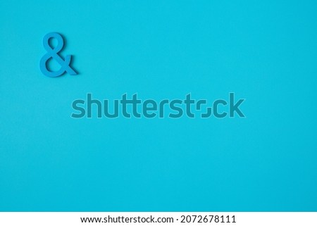 Blue wooden symbol "and" on blue background and copy space for social media educational concept