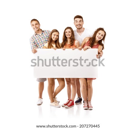 Group of happy young teenager students standing and smiling with blank placard board isolated on white background.