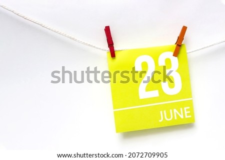 June 23rd. Day 23 of month, Calendar date. Paper cards with calendar day hanging rope with clothespins on white background. Summer month, day of the year concept