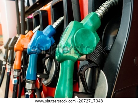 Petrol pump filling fuel nozzle in gas station. Fuel dispenser machine. Refuel fill up with petrol gasoline. Petrol industry and service. Red petrol fuel nozzle. Petroleum oil industry. Oil crisis. Royalty-Free Stock Photo #2072717348