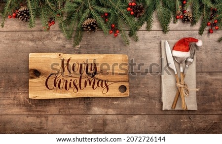Festive christmas, new year table setting with cutlery. Cutting board with merry christmas text. Restaurant menu background. Flat lay, top view