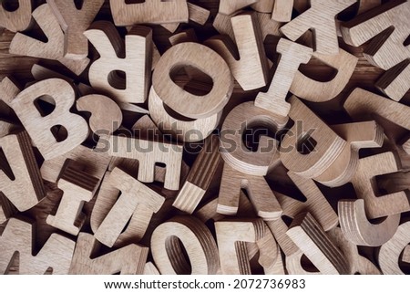 alphabets on a wooden surface. abc - letters.scattered mixed brown wooden letters of the English alphabet on white background, copy space, as a background composition