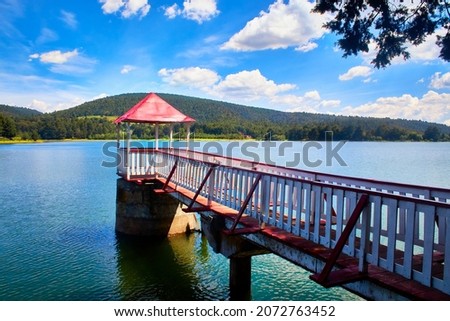 lake with a strutcture for looking with green forest in the background blue sky with some clouds in the oro de hidalgo state of mexico presa brockman Royalty-Free Stock Photo #2072763452