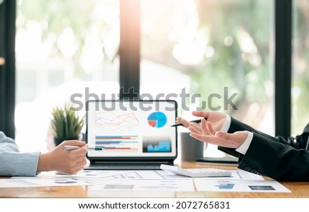 Cropped shot of business people hands holding pen and discussing about business plan, using computer and business graph, analyzing or calculating business results.