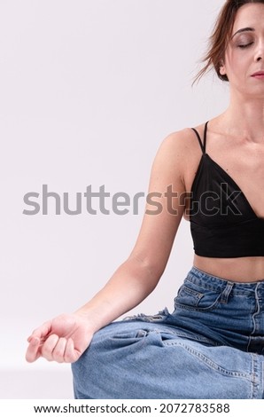 woman practicing yoga lesson, breathing, meditating. Half Lotus pose with mudra gesture, indoor close up. Well being, wellness concept