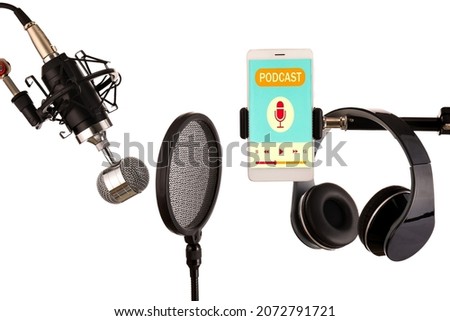 Modern microphone with pop filter, headphones and mobile phone on white background