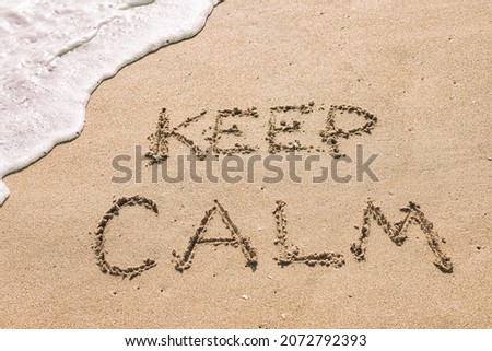 Keep calm written in the sand seashore of tropical beach with soft ocean wave. Relax, mindfulness, mental health, summer travel concept 
