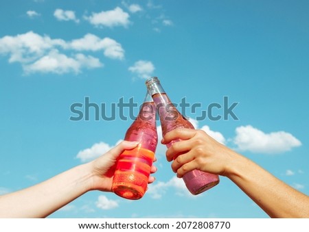 Clinking drinks with the cloudy sky background. Royalty-Free Stock Photo #2072808770