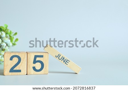 June 25, Calendar cover design with number cube with green fruit on blue background.
