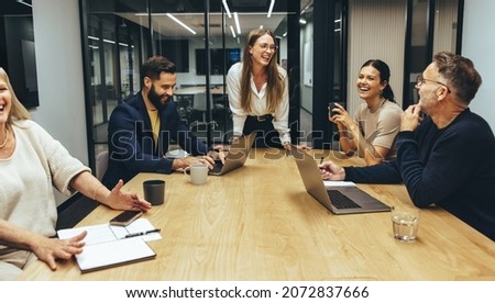 Colleagues laughing cheerfully during a meeting in a boardroom. Group of happy businesspeople enjoying working together in a modern workplace. Successful business professionals collaborating. Royalty-Free Stock Photo #2072837666