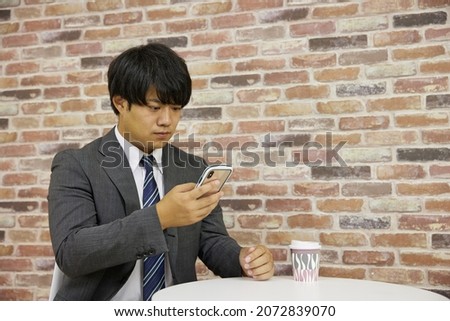 A businessman touching a mobile phone in a suit