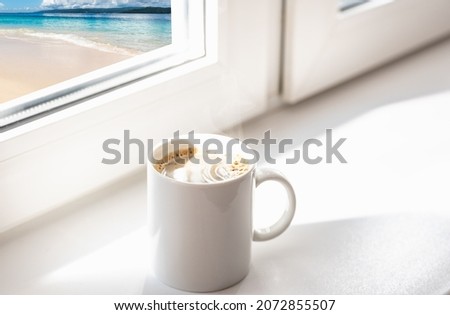 cup of coffee at  window overlooking the sea summer